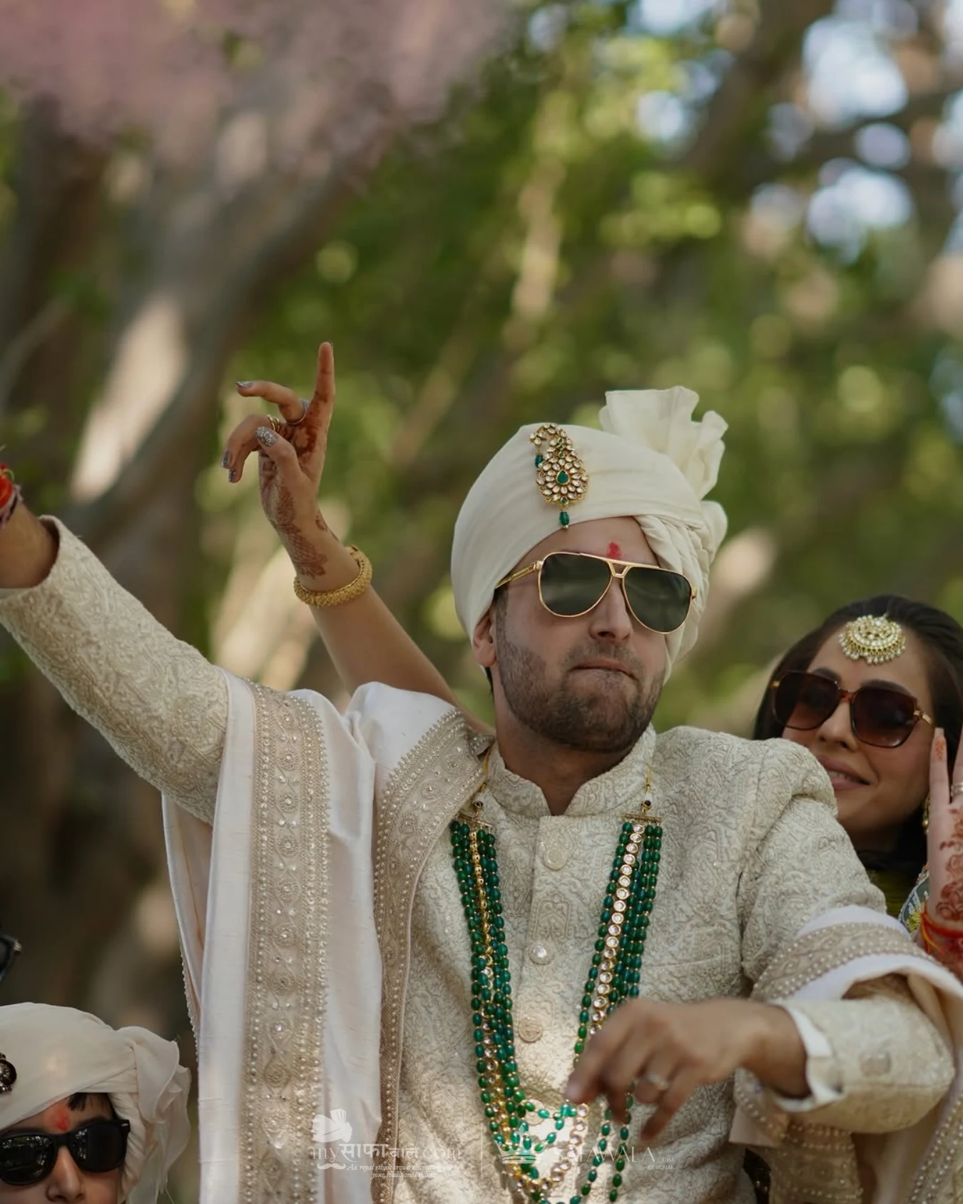 Groom in an ivory wedding safa with emerald jewellery for Fatehgunj